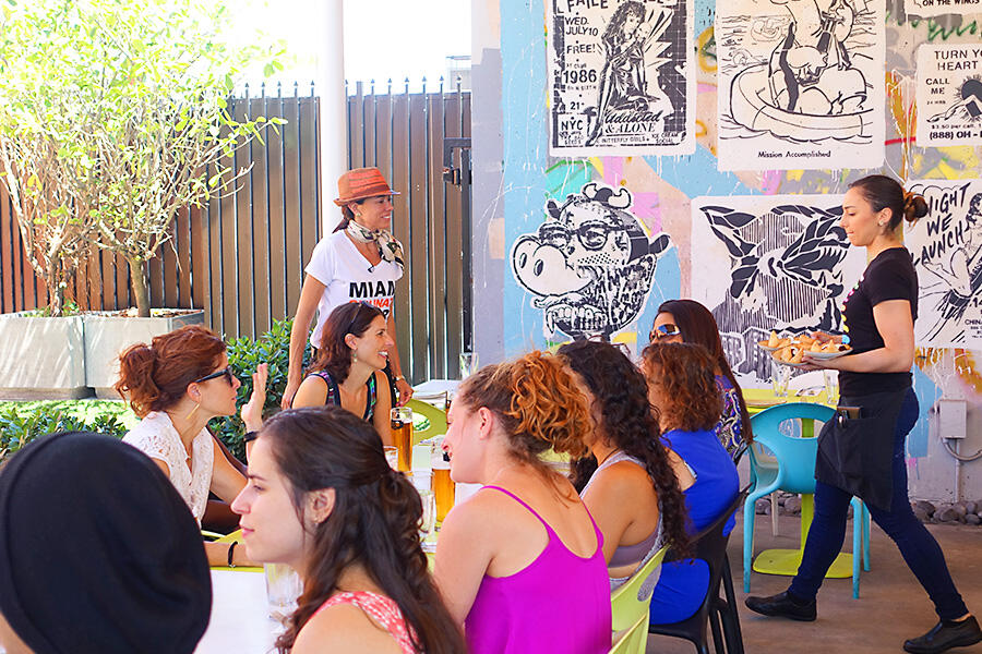 A group of people having a Private Experience, sitting around a table in Little Havana.