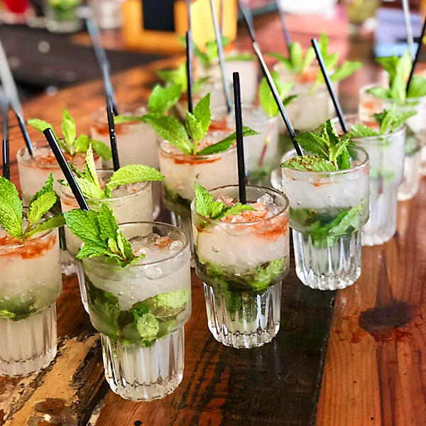 Several glasses of mojitos on a wooden table in Little Havana.