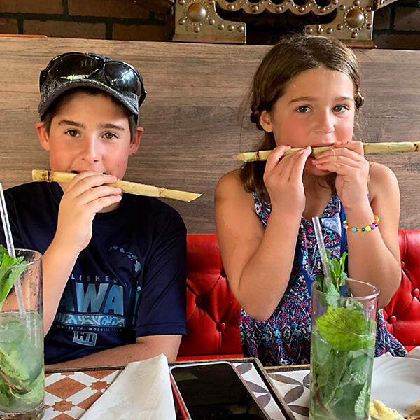 A boy and a girl enjoying a culinary experience at a table in Little Havana during their Miami Food Tours adventure.