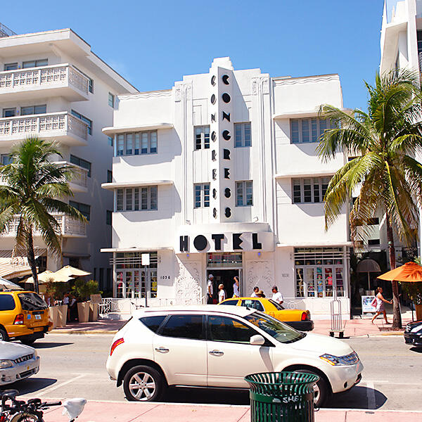 A white building surrounded by palm trees, offering Miami Food Tours and Private Culinary Tours.