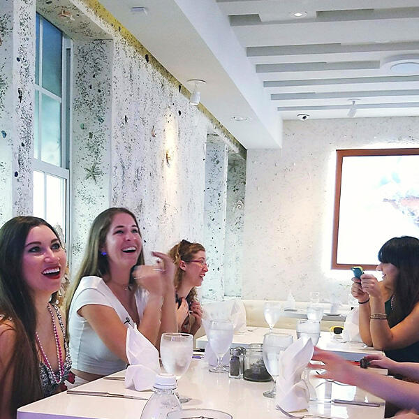 A group of women sitting at a table in a restaurant during a culinary tour experience.