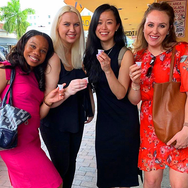 A group of women on a Private Tour posing for a picture in front of a store.