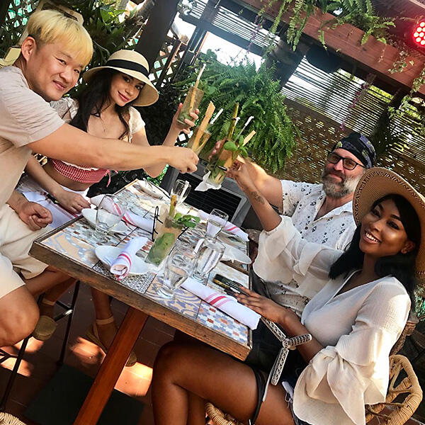 A group of people enjoying a private tour at an outdoor table while toasting.