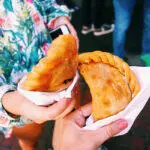 A woman enjoying a delicious sandwich during a Miami Food Tour.