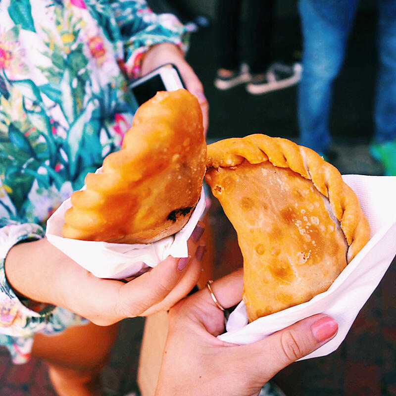 A woman enjoying a delicious sandwich during a Miami Food Tour.