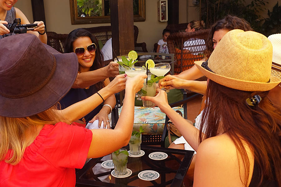 A group of women enjoying a culinary tour at a table with drinks.