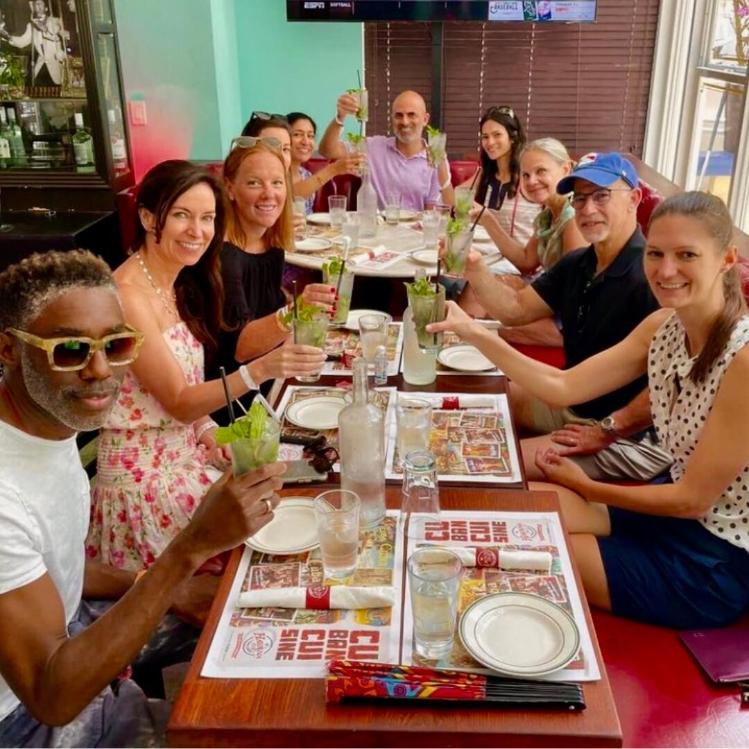 A group of people posing for a picture at a restaurant during a private tour.