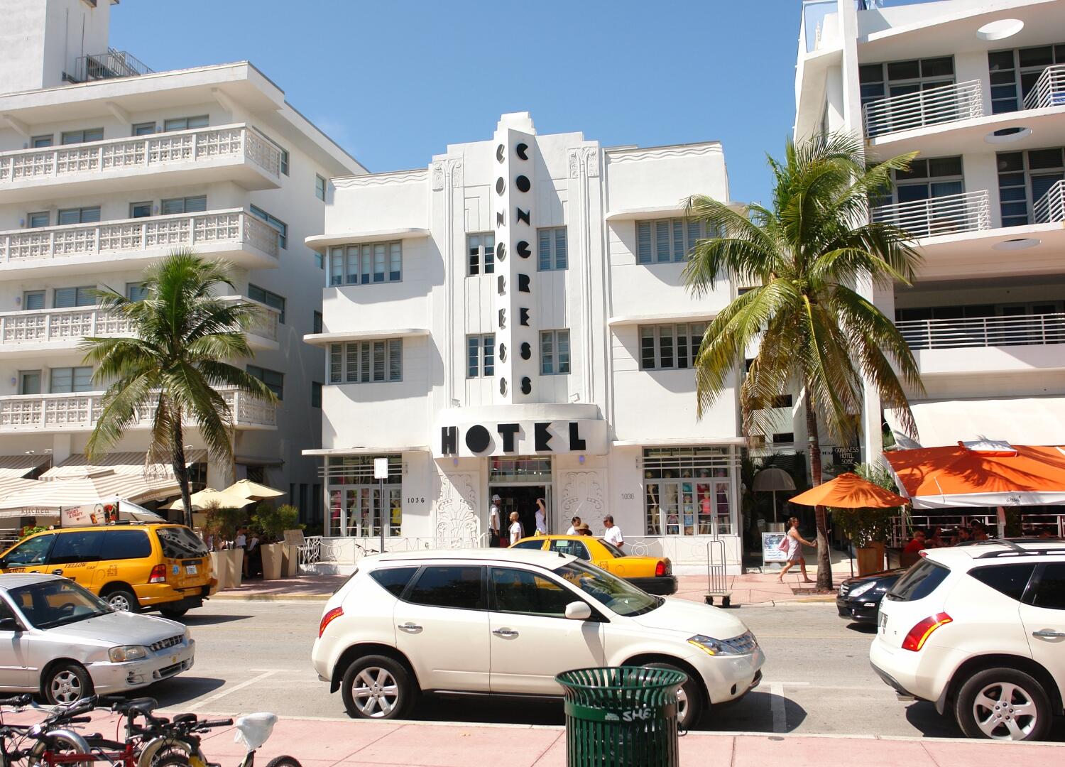 A street scene with cars parked in front of a hotel, ideal for Miami Food Tours and Group Tours.