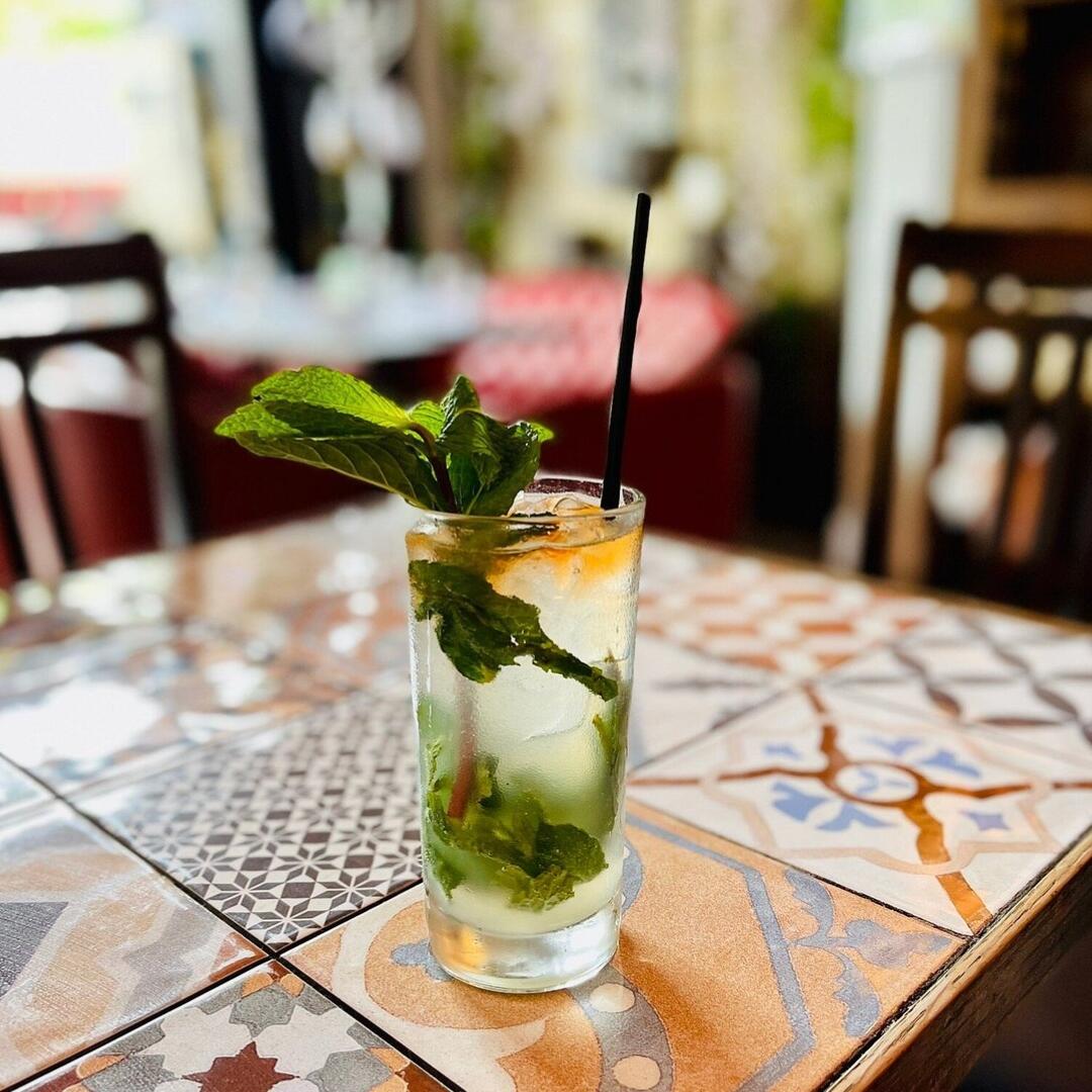 A glass of mojito sitting on a tiled table during a Miami Food Tour.