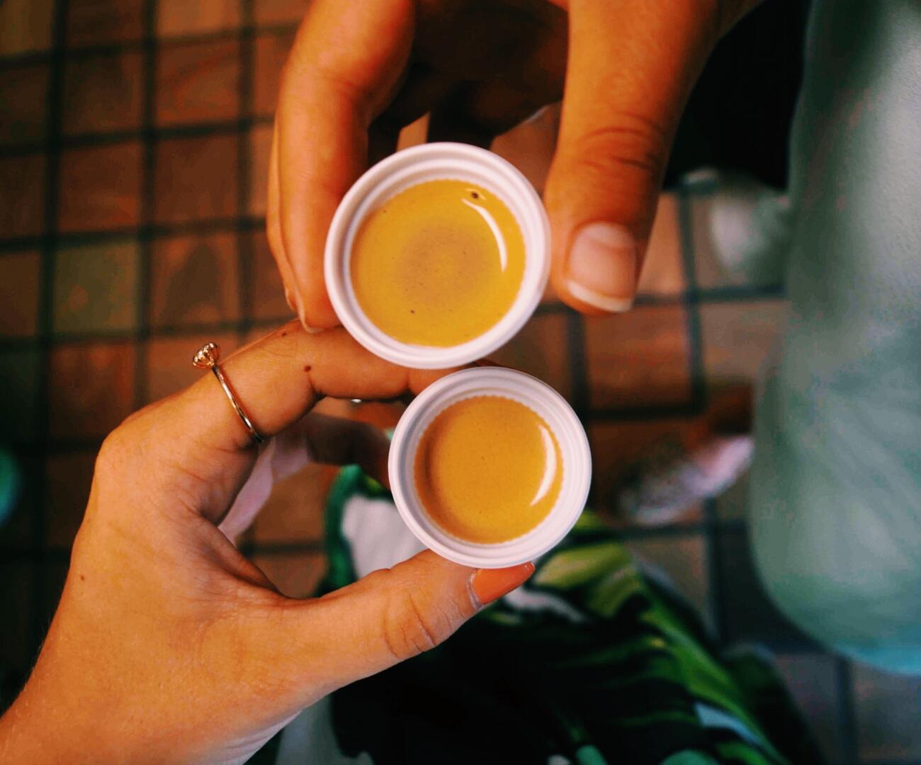 Two people holding two cups of liquid during a private tour.