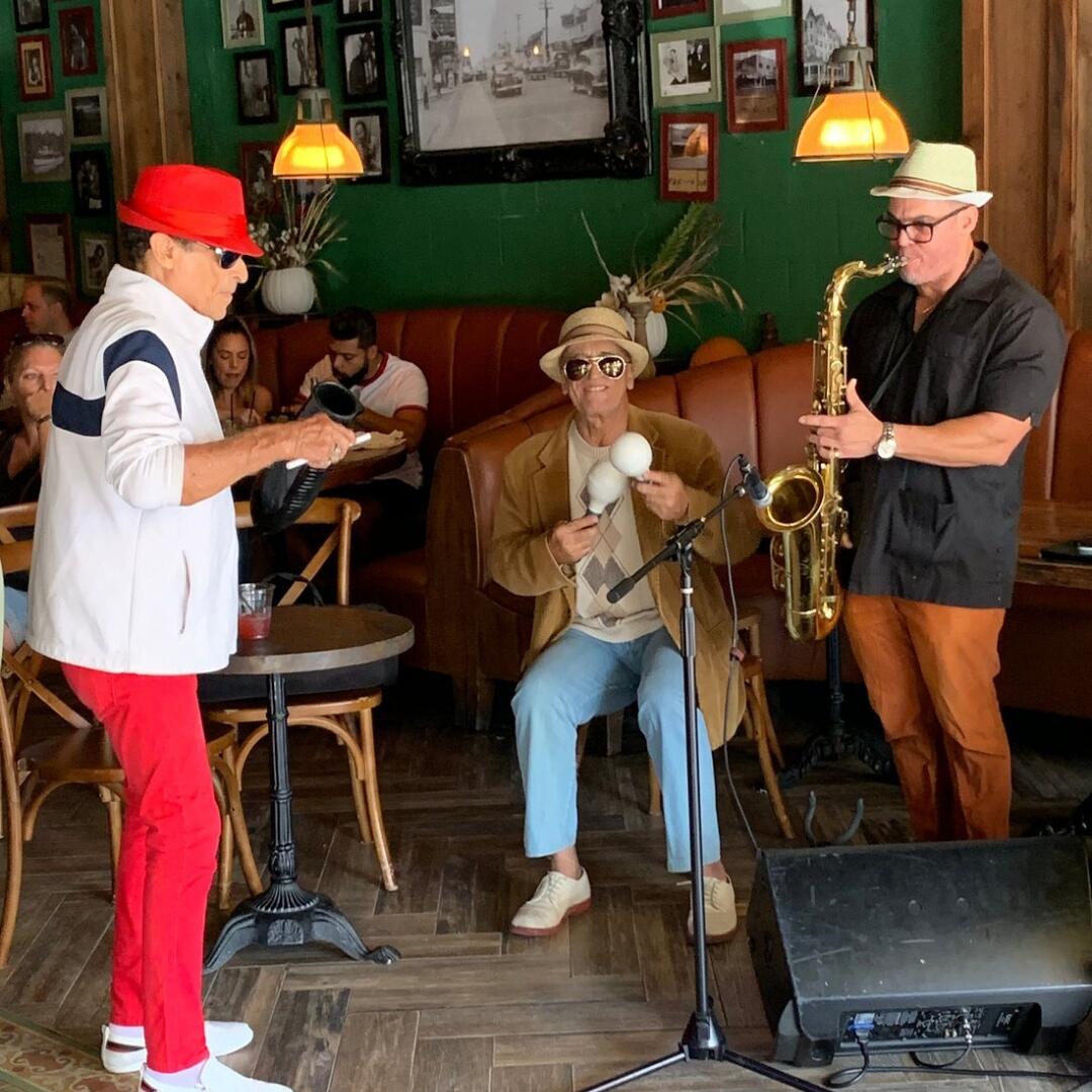 Three men playing saxophones during a private event in a restaurant.