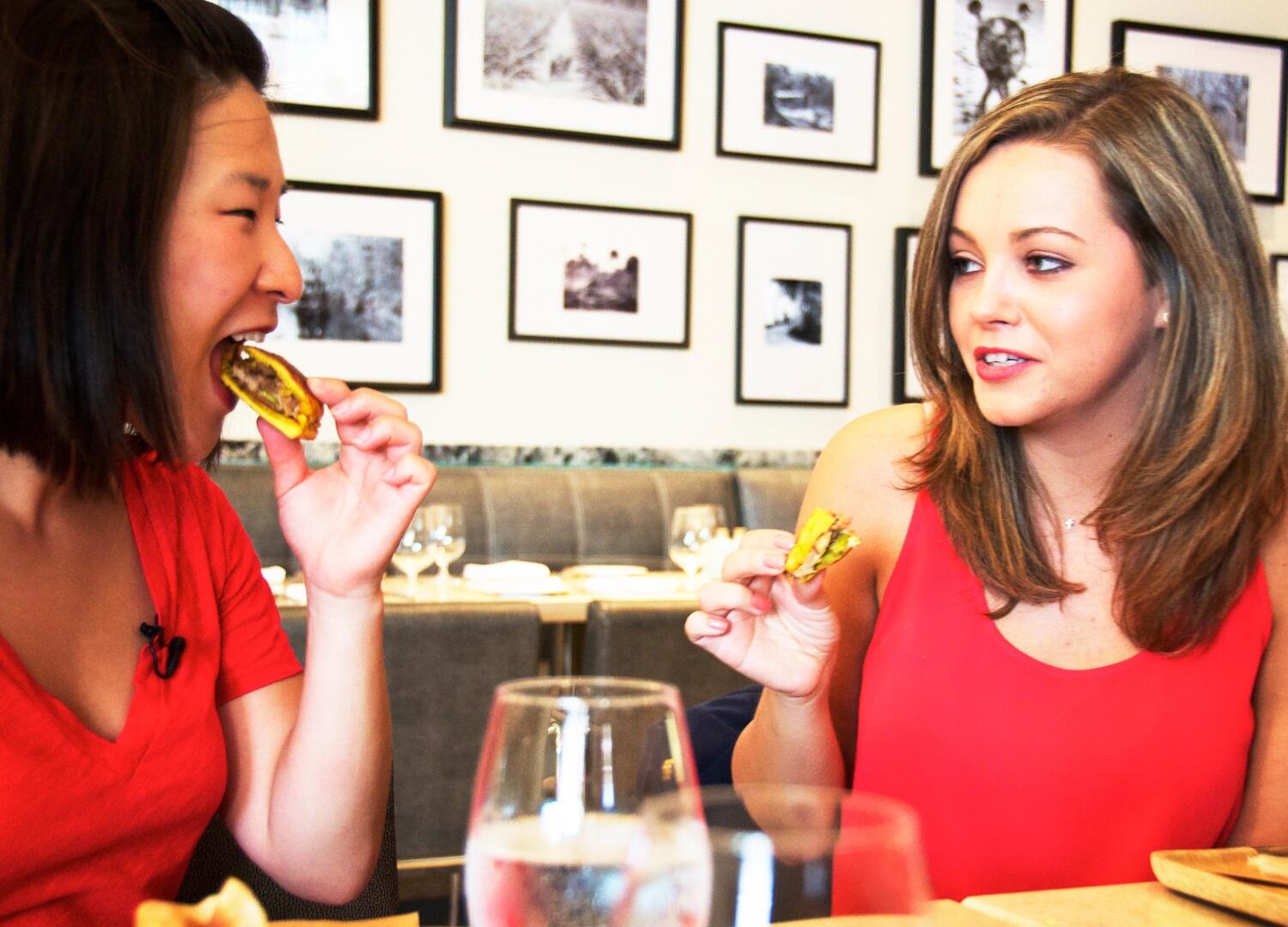 Two women enjoying a culinary experience at a restaurant on a private food tour in Miami.