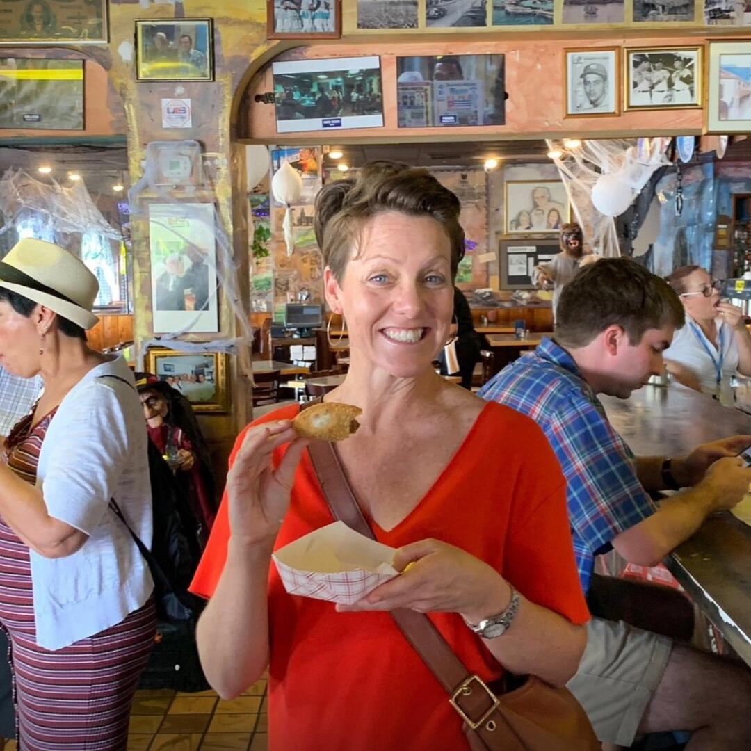 A woman indulging in a donut during a culinary tour at a restaurant.