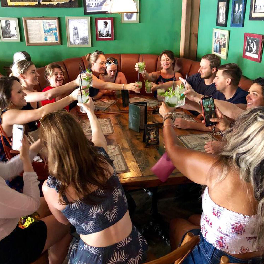 A group of people enjoying a culinary tour at a table in a restaurant.