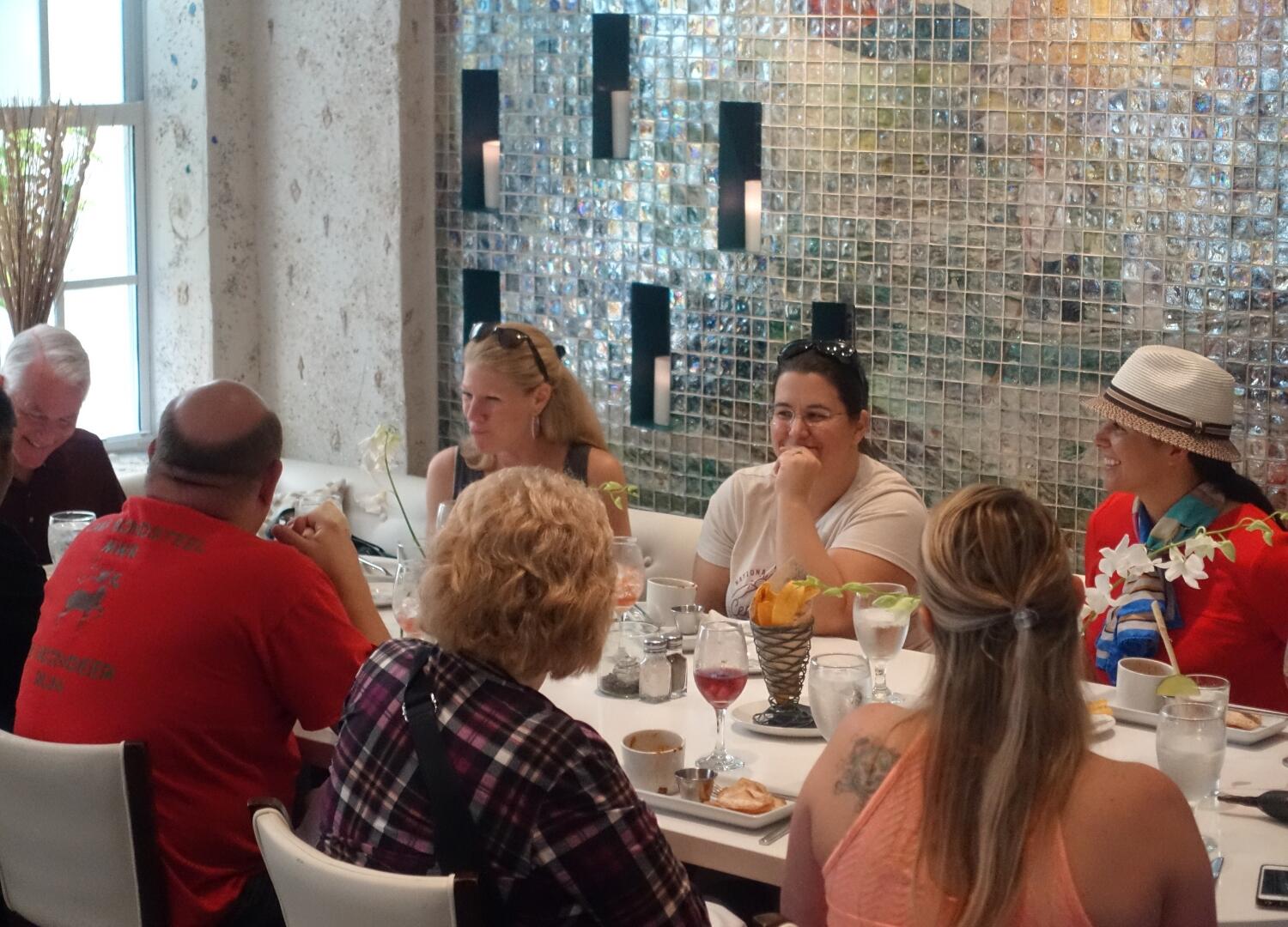 A group of people enjoying a culinary tour at a table in a restaurant.