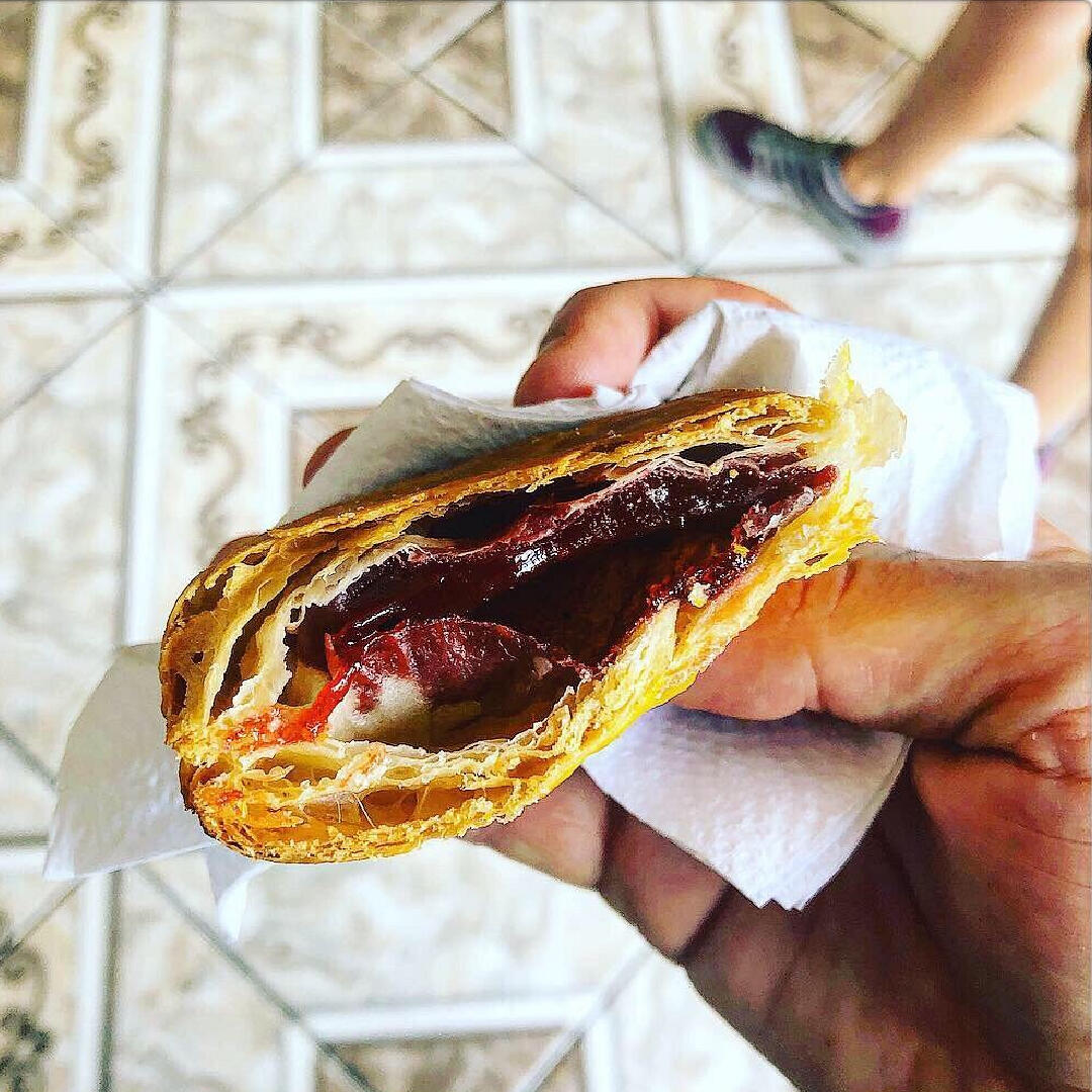 A person holding a pastry on a Miami Food Tour.