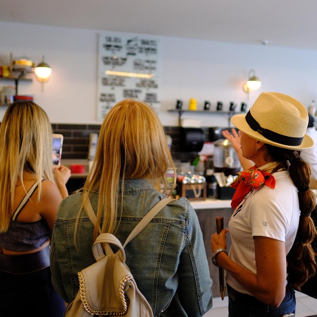 A group of women on a culinary tour standing in front of a coffee shop.