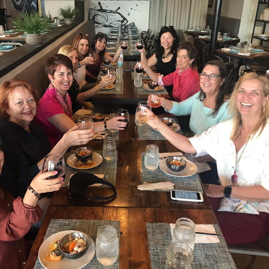 A group of women on a culinary tour posing for a photo at a restaurant.