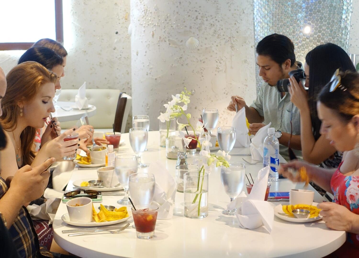 A group of people on a Miami Food Tour, enjoying a culinary experience at a table in a restaurant.