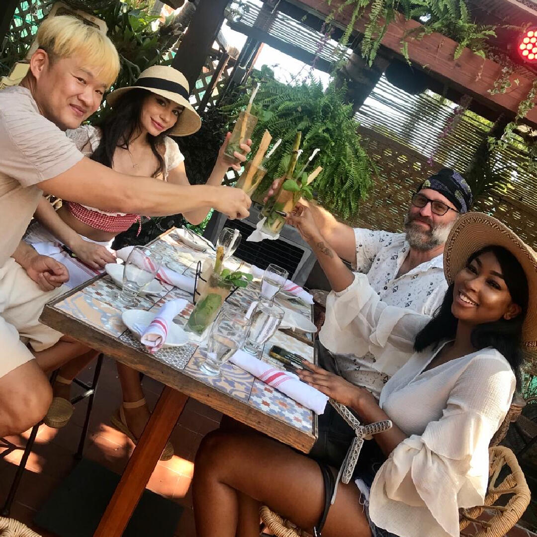 A group of people enjoying a culinary tour at an outdoor table, toasting and savoring their delectable dishes together.
