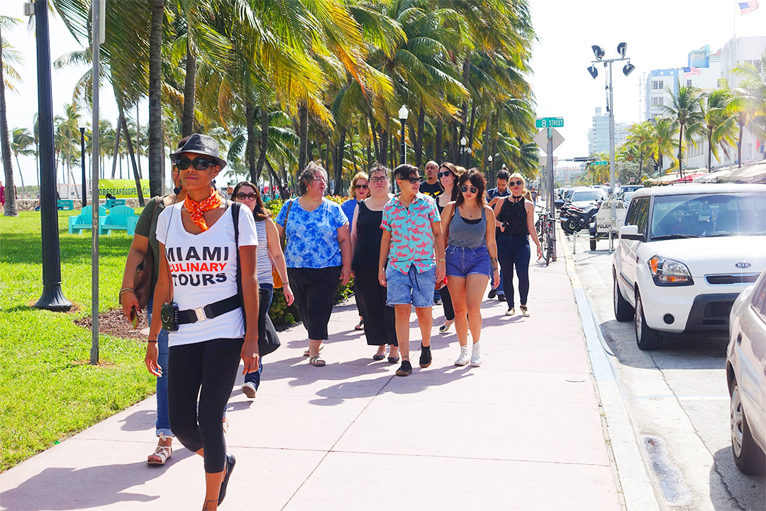 A group of people on a Miami Food Tour walking down a sidewalk.