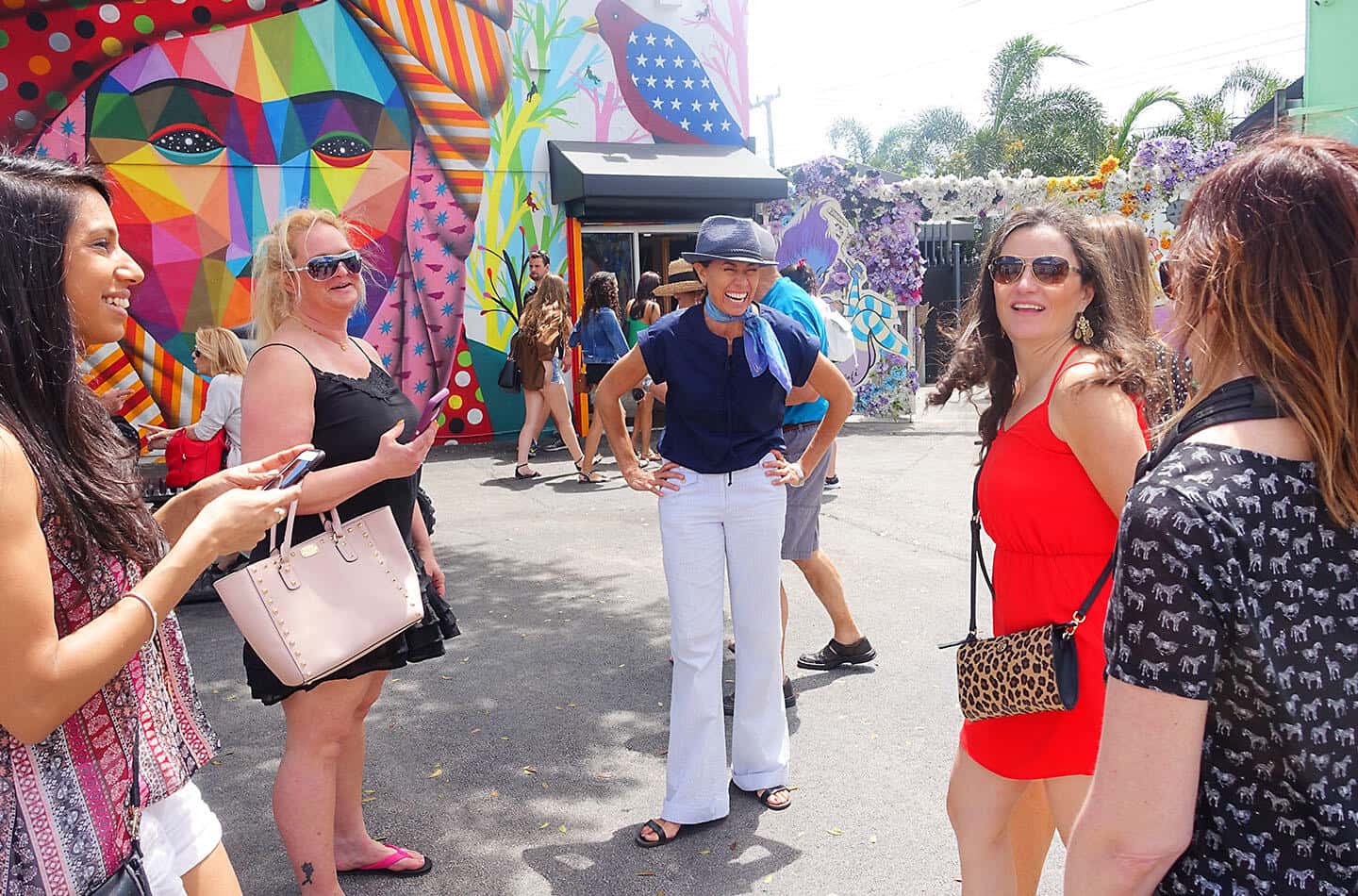 A group of women on a private tour standing in front of a colorful mural.