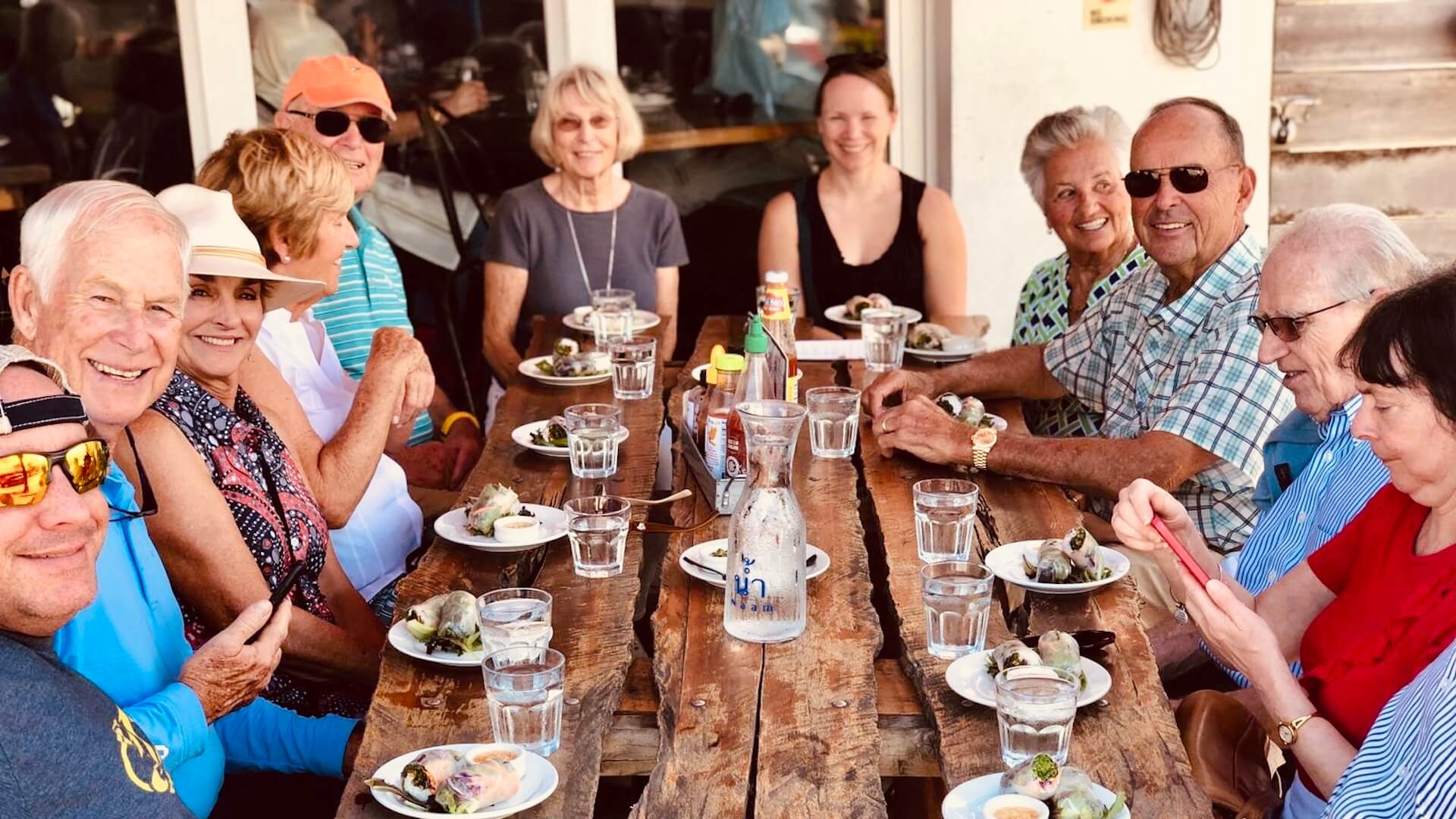 A group of people enjoying a meal together at an outdoor table.